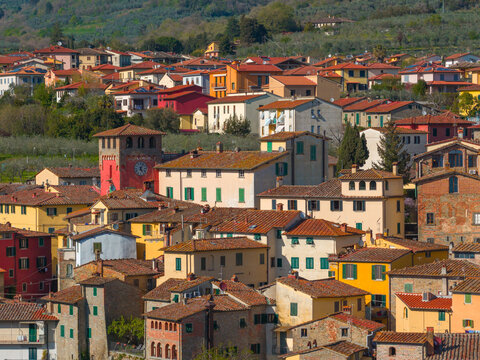 Aerial view of Loro Ciuffenna with colorful terracotta rooftops, stone buildings, and a prominent clock tower nestled in the hills of Tuscany, Loro Ciuffenna, Tuscany, Italy.