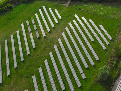 Aerial view of rows of solar panels installed in a green field in the countryside, Hrusky, South Moravian Region, Czechia.
