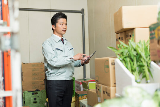 搬入口で荷受け作業をする40代男性
