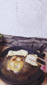 Person POV of frying traditional food Langos in hot oil