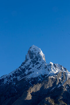 View of the snow-capped peak of K2 rising against a clear blue sky in the Karakoram range in Gilgit, Pakistan.
