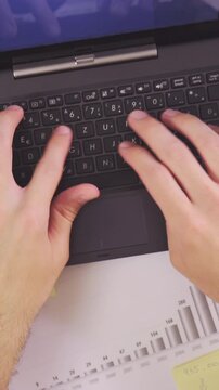 Person type on laptop computer top view of messy table