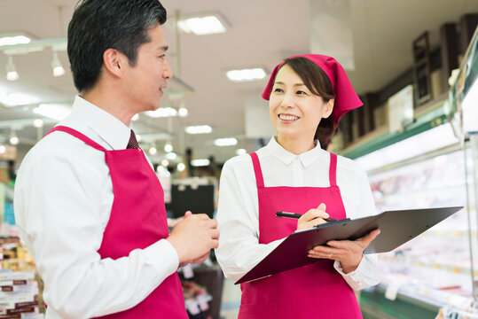 精肉売り場で打ち合わせする40代の男女店員