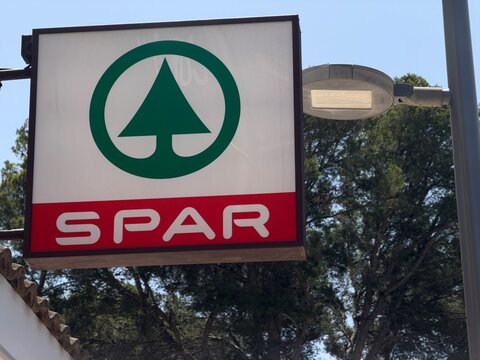 Mallorca, spain, june 20, 2026 spar supermarket sign displaying branding logo with fir tree icon, retail grocery store on a sunny day