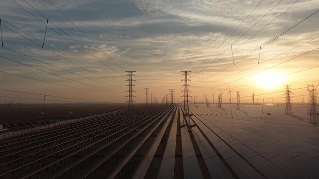 Solar Farm and Power Transmission Towers at Sunset