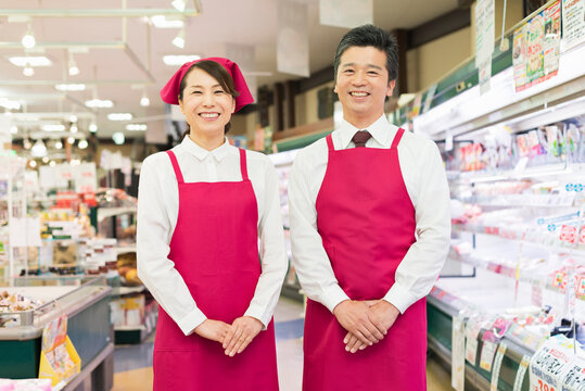 精肉売り場で打ち合わせする40代の男女店員