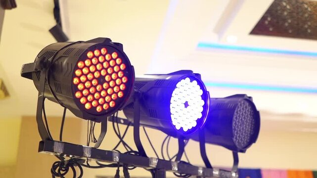 Close-up footage of colorful LED stage lights illuminating an indoor wedding venue. Ideal for themes related to entertainment, event production, stage technology, and venue decoration.