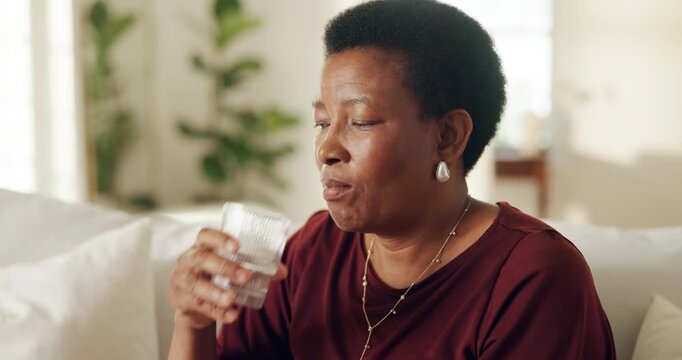 Water, pills and black woman in home for medical treatment, prescription and tablets for recovery. Healthcare, mature person and medication in living room for vitamins, supplements and drugs on sofa
