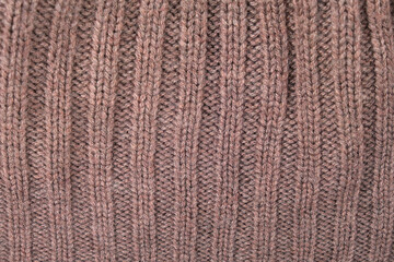 Fototapeta premium Brown knitted wool fabric texture. Soft sweater surface with rib pattern. Close up view of textile material for clothing design and construction. Winter apparel background concept.