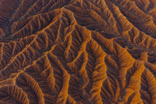 Aerial view of the intricate eroded ridges and orange sandstone formations of Ak Say Canyon, also known as the Valley of Forgotten Rivers, Ak Say, Issyk-Kul Region, Kyrgyzstan.