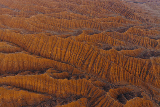 Aerial view of the unique red rock formations and eroded ridges of Ak Say Canyon and the Valley of Forgotten Rivers in Ak Say, Issyk-Kul Region, Kyrgyzstan.