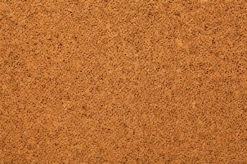 Fototapeta premium Close-up view of a natural cork's porous texture, showcasing warm brown tones on a minimalist background.