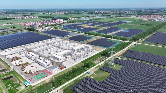 Aerial view of a large-scale photovoltaic power station with adjacent substation facilities