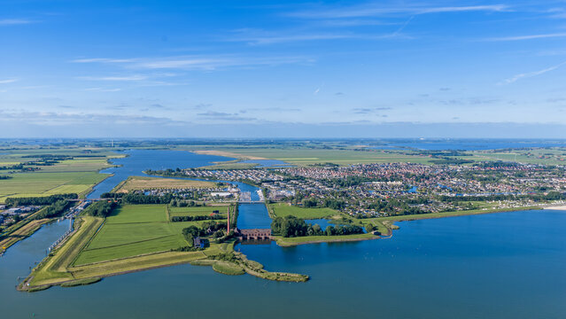 Aerial view of the historic Wouda pumping station with its tall chimney on the shore of the IJsselmeer near the town of Lemmer, Friesland, Netherlands.