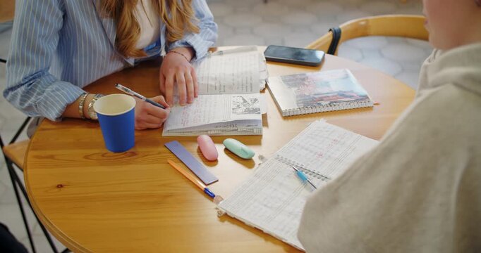 Students comparing handwritten notes during study session