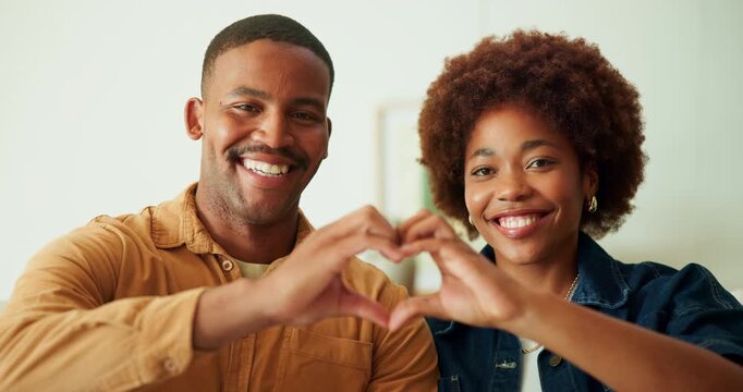 Face, smile and couple with heart in house, commitment and love symbol with partner and anniversary. Black people, home and shape with hand gesture in living room, happy and connection with spouse