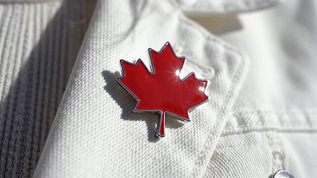 Macro Shot of a Red Maple Leaf Pin on a White Denim Jacket Lapel with Shallow Depth of Field Highlighting Vibrant Colors and Fashion Details