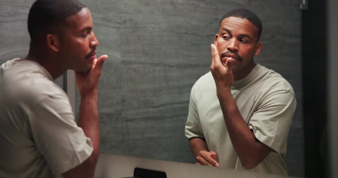 Checking, mirror and skincare with black man in bathroom of home for morning grooming or hygiene. Beauty, inspection and reflection with person in apartment for health, self care or wellness routine