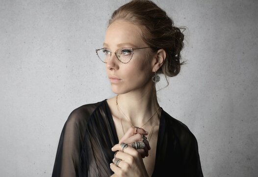 Elegant woman in cat eye glasses looking pensive
