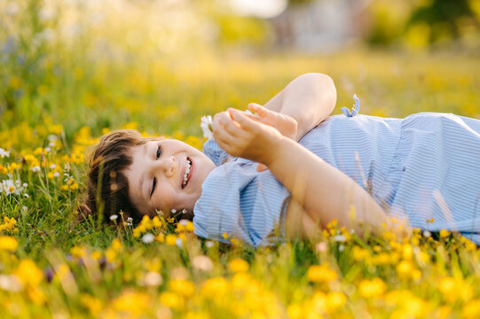 Happy young girl relaxing in flower meadow