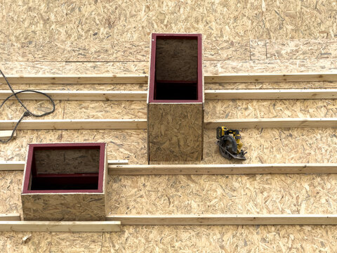 Aerial view of wooden roof decking under construction with two rectangular openings and a circular saw in Istanbul, Istanbul, Turkiye.
