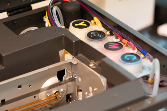 Refill color tanks on dtf textile printer. Printer ink supply system showing four primary color tanks