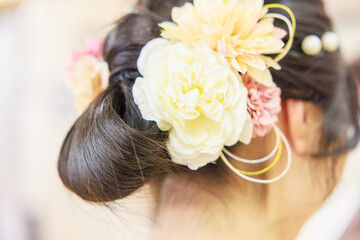 Naklejka premium 華やかな造花の髪飾りをあしらった着物姿の女性のヘアスタイル（後ろ姿）