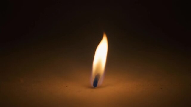 Small isolated flame burning gently with realistic fire movement and warm glow. Minimal cinematic composition suitable for fire concepts, energy themes, candle visuals, and atmospheric projects.