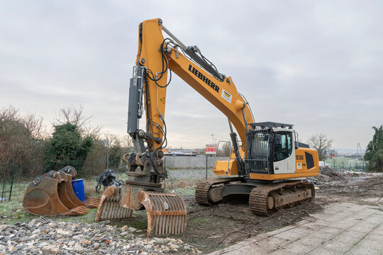 Tomblaine, France - January 3rd 2019 : View on a yellow crawler excavator Liebherr R 936 Litronic for the d&eacute;molition of an old building on a construction site.