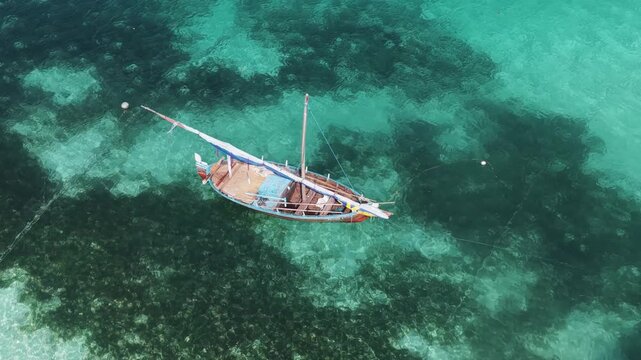 Aerial view of traditional wooden dhoni boat floating in clear turquoise water Vaikaradhoo, Haa Dhaalu Atoll, Maldives.