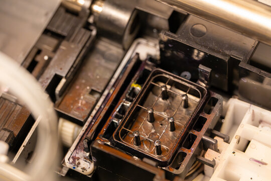 Ink runoff pad on DTF textile printer cleaned during maintenance.