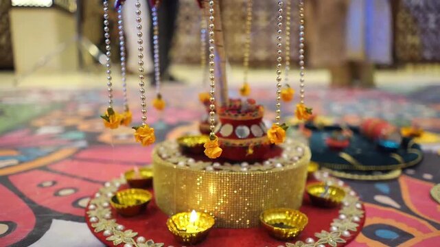 Close-up footage of a traditional Mehndi ceremony centerpiece featuring decorative hanging ornaments, colorful lighting, and handcrafted wedding decor. 