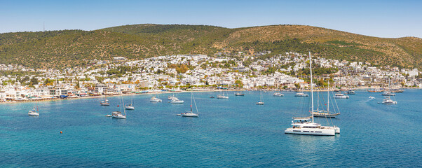 Bodrum panoramic view featuring many yachts anchored in the Aegean Sea, with white buildings covering the hillside © EdNurg