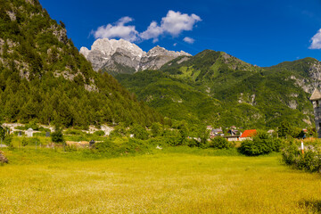 Obraz premium Mountain landscape in the Albanian Alps near Theth, Albania. Theth Valbona valley trek Peaks of the Balkans scenic way. Rugged peaks rise above forested valleys and alpine meadows