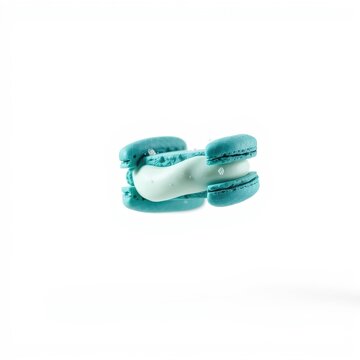 Pastel macaron sandwich. Turquoise shells embrace mint filling. Delicate dessert, studio shot, isolated, clean background.