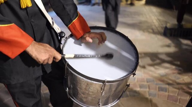 Close-up video of a marching band drummer playing a traditional drum during a wedding celebration. The footage captures live music performance, rhythmic drumming, festive atmosphere, cultural event