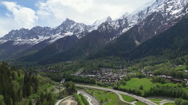 Aerial view of the town of Chamonix nestled in the lush green valley surrounded by snow-capped peaks of the Mont Blanc massif in Chamonix, Auvergne-Rhone-Alpes, France.