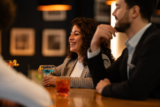 Happy business people enjoying after work drinks at a bar