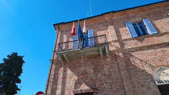 Historic Brick Town Hall with Balcony and Flags in Piedmont Italy