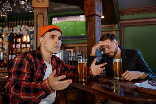 Upset viewer with engrossed expression. Fans showing frustration during intense game in a pub