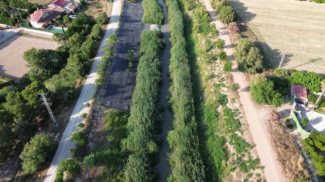 Aerial view of the Segura riverbed restoration project using protective plastic covers on riverbanks to eradicate the invasive Arundo donax giant reed protecting agricultural landscape ecology 