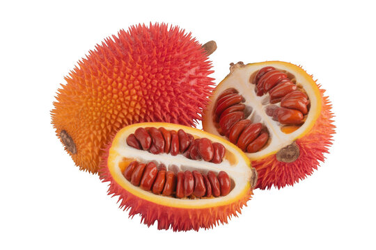 Whole and halved gac fruit with red seeds isolated on a transparent background