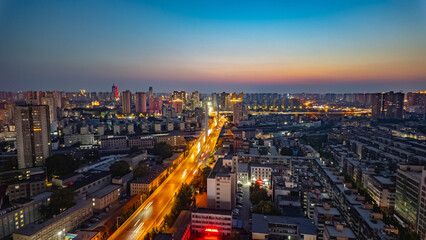 Obraz premium Drone Shot of Zhengzhou Downtown at Twilight with Gradient Sunset Sk