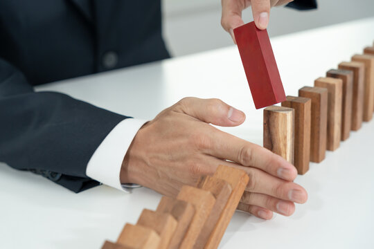 insurance with hands protect domino. Businessman hands stop dominoes falling in business crisis. business risk control and planning and strategies to run prevent insurance businesses.
