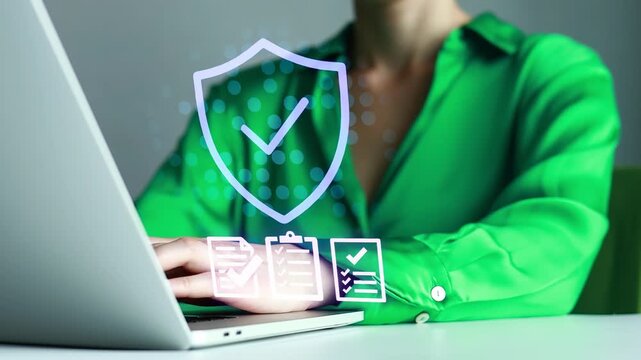 Person works on laptop with security symbols on screen in an office setting during the day.
