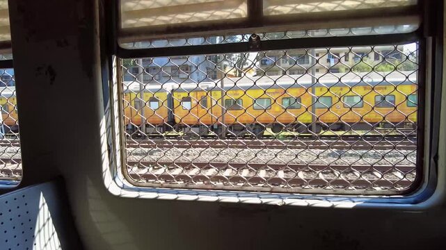 Passenger View Through Grilled Train Window in Mumbai