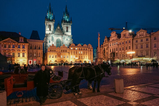 Prague, Czechia - 03 November 2021: View of the Church of Our Lady before Tyn at night with a horse-drawn carriage and driver in the Old Town Square.