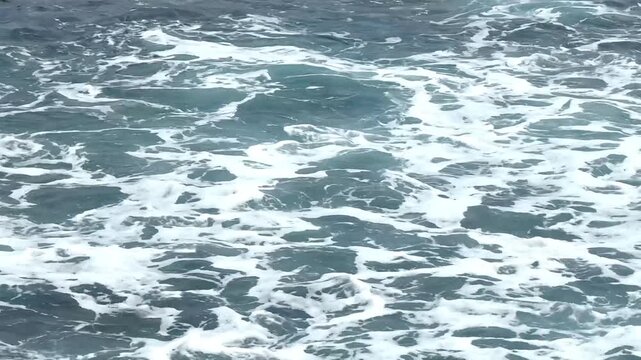 Rough sea water surface with splashing white wave foam footage, perfect for cinematic b-roll transitions, nature documentaries, marine life backgrounds, and dramatic travel marketing assets