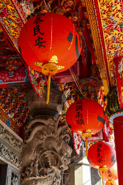 Taipei, Taiwan - 15 January 2026: View of traditional red lanterns hanging from the ornate ceiling of a temple in Taipei, featuring intricate dragon carvings and vibrant gold decorations.