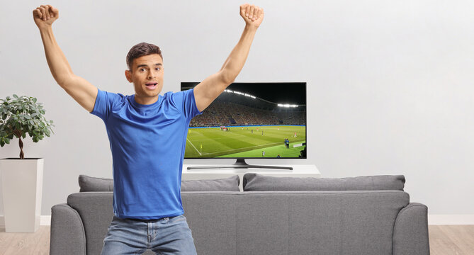Young man watching football on tv